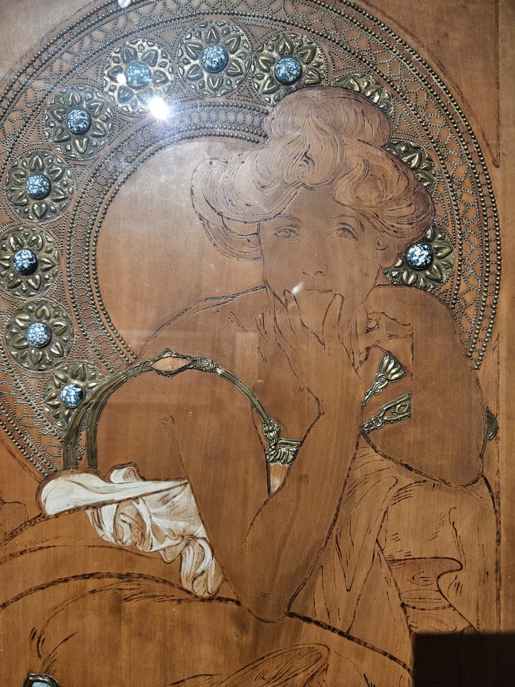 Détail d'un panneau en bois orné de pierres, exposition Mucha Lyon